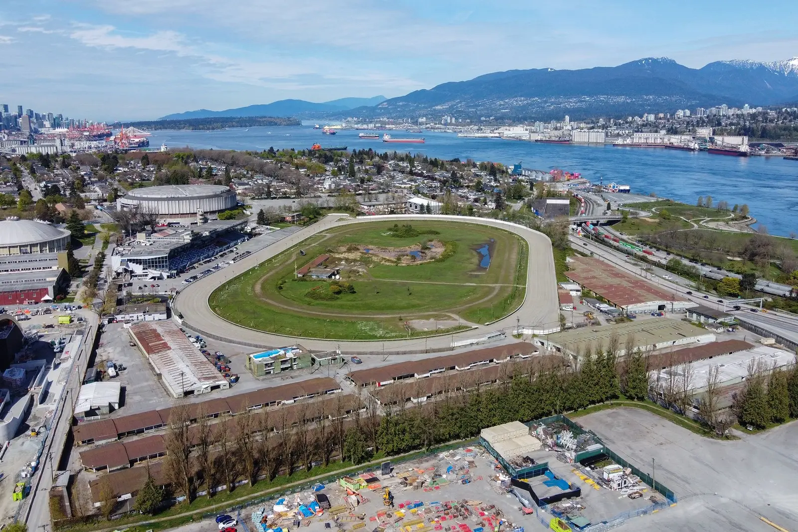 Aerial view of Hastings Racecourse and its grandstand in Hastings Park, with Burrard Inlet and the North Shore mountains